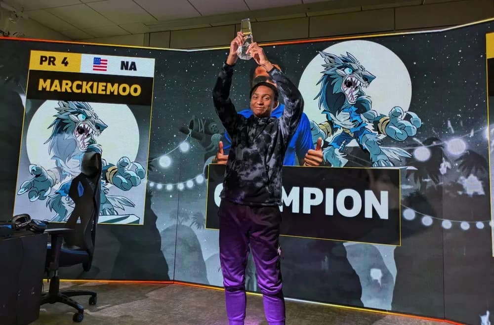 Marckiemoo holding the trophy in front of his championship screen